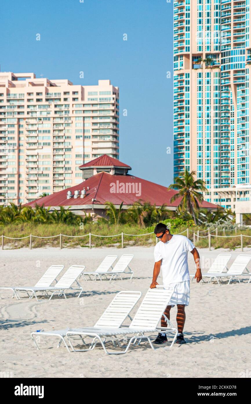 Miami Beach Florida,ispanico Latino latino immigranti etnici immigrati minoranza,adulti adulti uomo uomini maschio,organizzazione preparazione noleggio sedie a sdraio Foto Stock