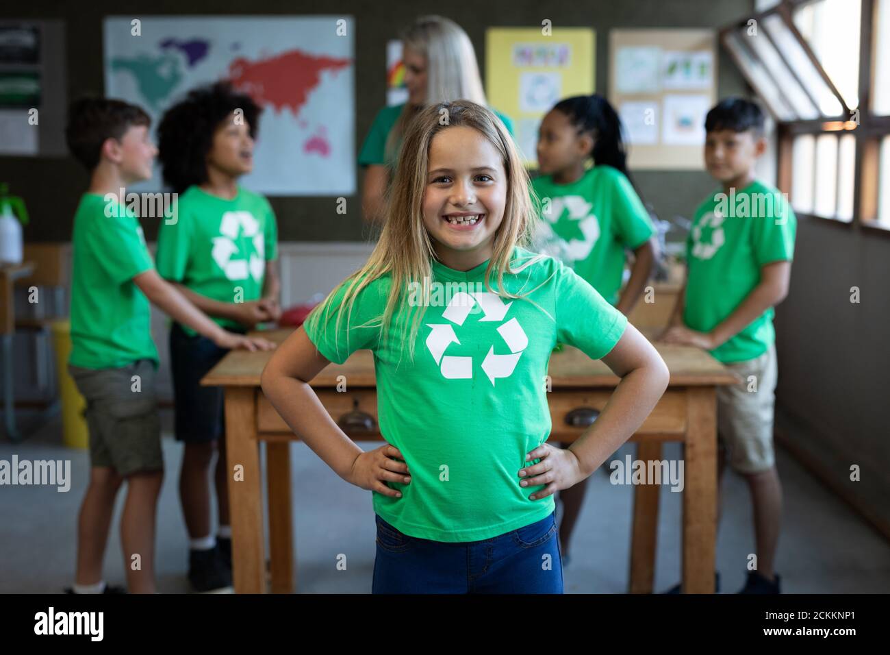Ritratto di ragazza che indossa t-shirt di riciclo in piedi con lei mani sui fianchi in classe Foto Stock