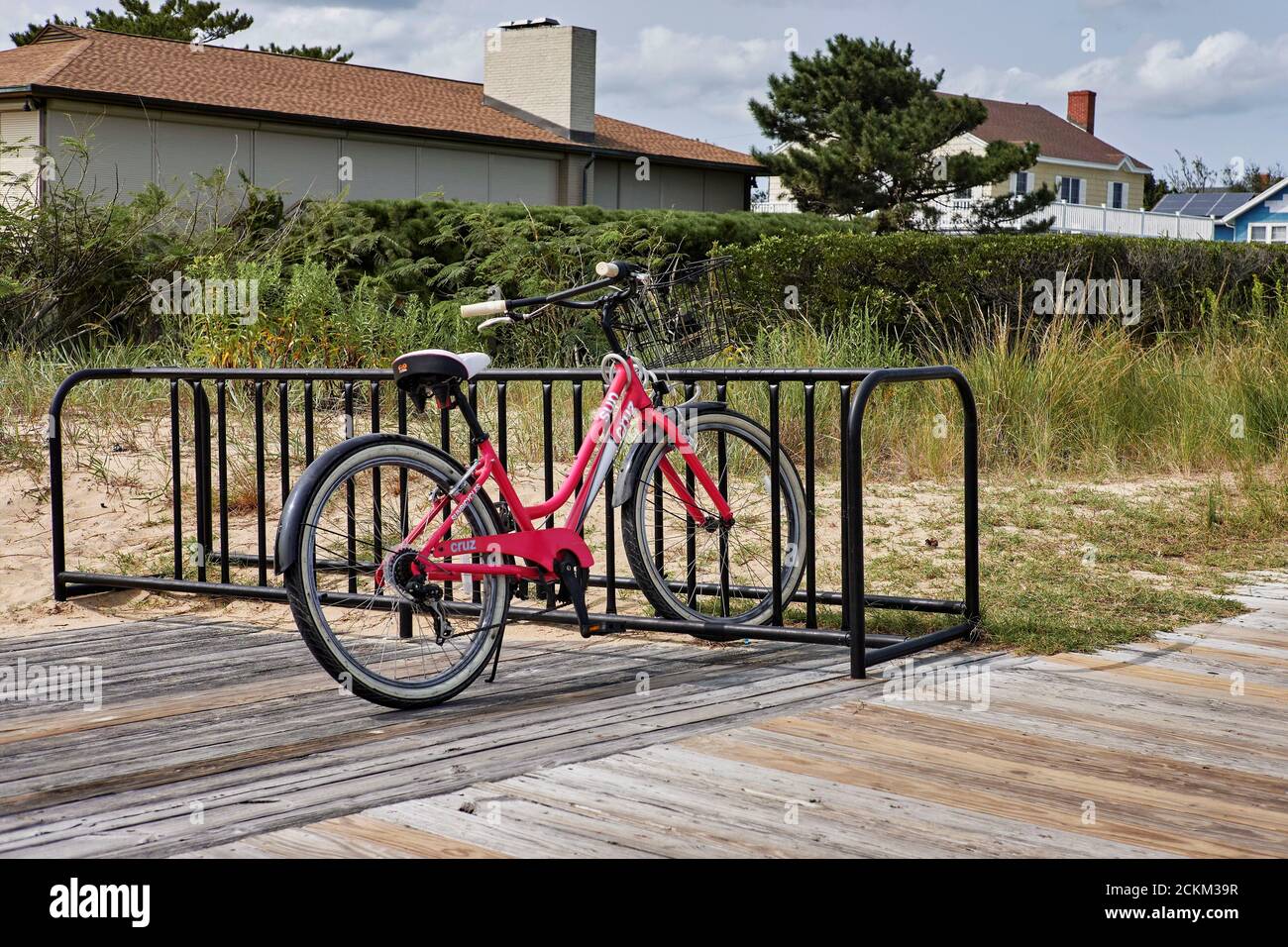 Una bicicletta rosa da donna parcheggiata in un portabiciclette. Foto Stock