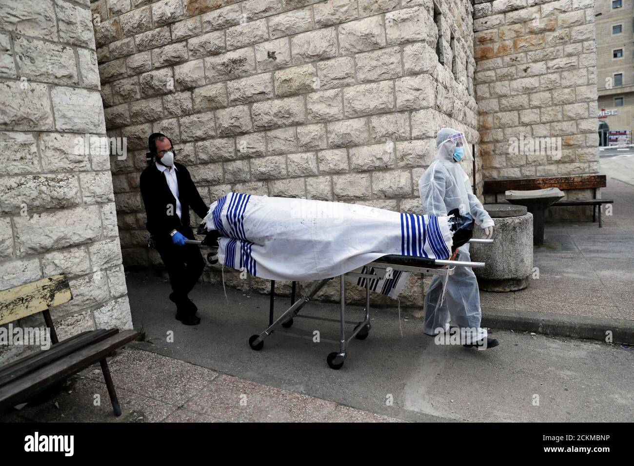I lavoratori della Jewish Burial Society indossano indumenti protettivi quando portano il corpo di una vittima della malattia del coronavirus (COVID-19) da seppellire a Gerusalemme il 2 aprile 2020. REUTERS/Ronen Zvulun Foto Stock