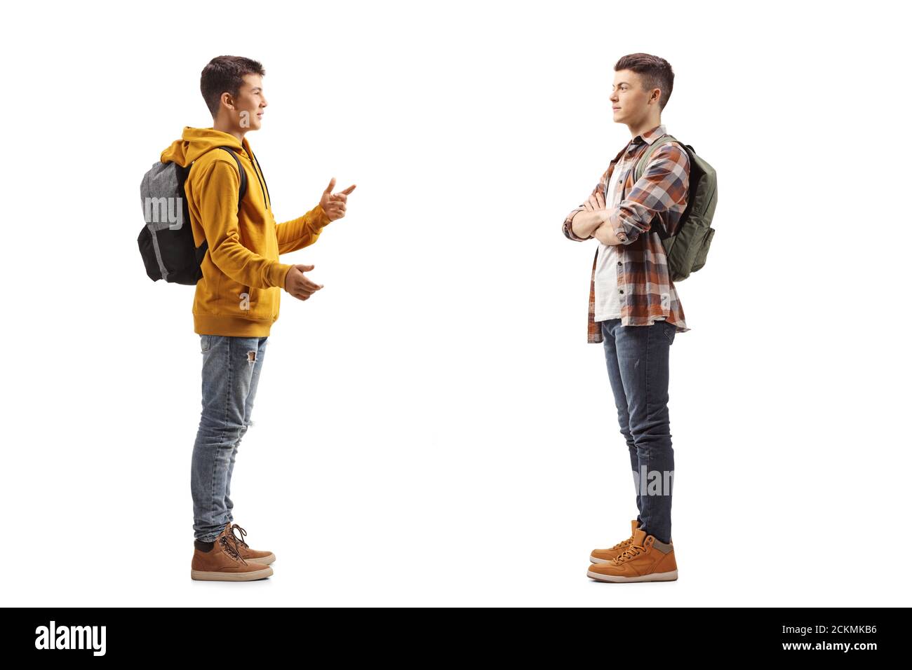 Foto di profilo a lunghezza intera di due ragazzi adolescenti che hanno una conversazione isolata su sfondo bianco Foto Stock