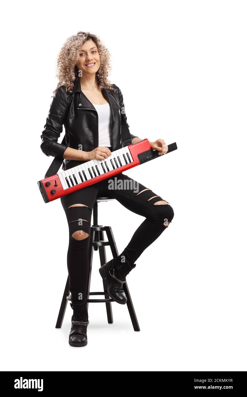 Ritratto a lunghezza intera di una donna fresca con un keytar sintetizzatore seduto su una sedia isolata su sfondo bianco Foto Stock