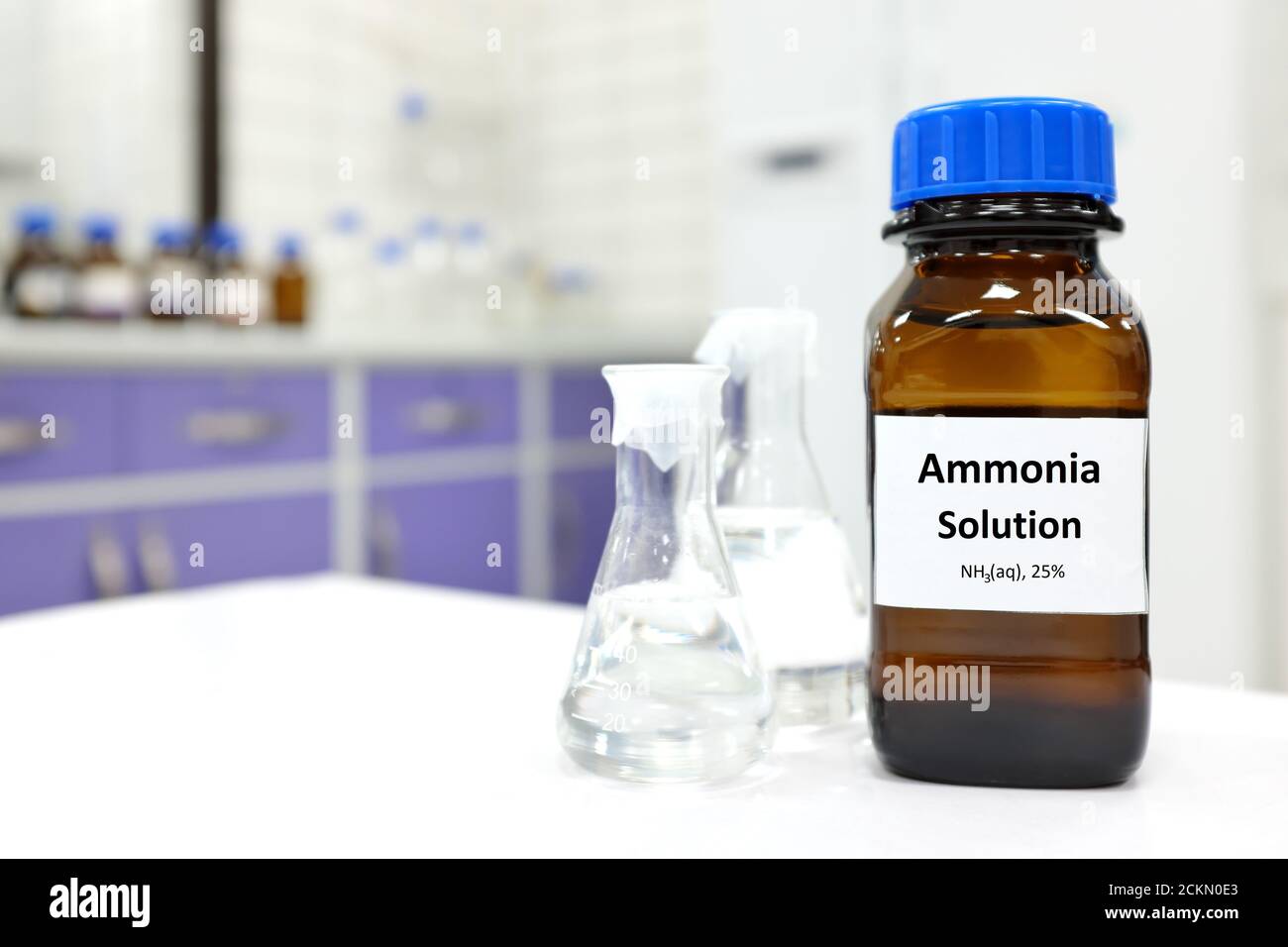 Concentrazione selettiva di soluzione di ammoniaca o idrossido di ammonio in vetro flacone ambrato all'interno di un laboratorio chimico con spazio per la copia Foto Stock