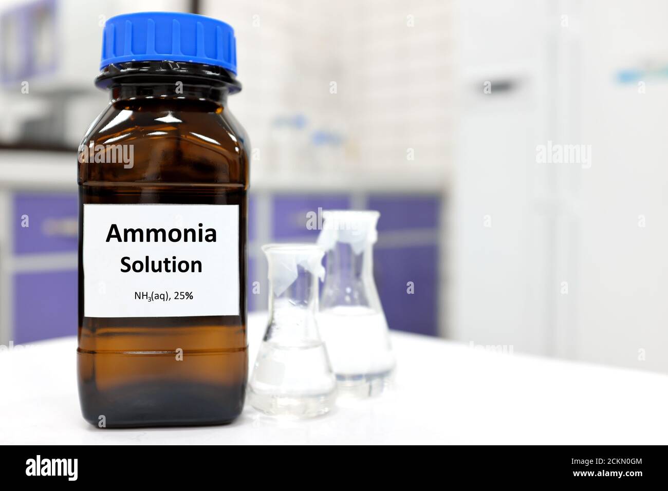 Concentrazione selettiva di soluzione di ammoniaca o idrossido di ammonio in vetro flacone ambrato all'interno di un laboratorio chimico con spazio per la copia Foto Stock