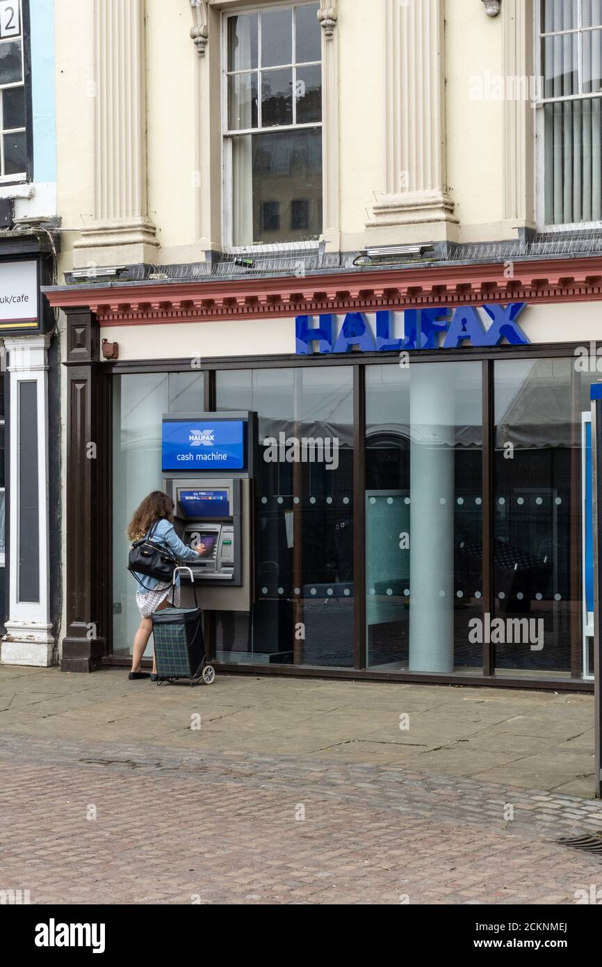 Frontage di Halifax Bank, Market Square, Northampton, UK; donna che usa ATM esterno. Foto Stock