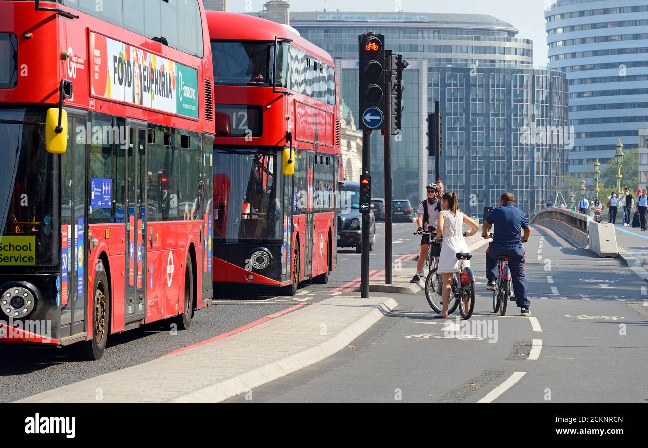 Londra, Inghilterra, Regno Unito. Ciclisti nella pista ciclabile e autobus sul Westminster Bridge Foto Stock
