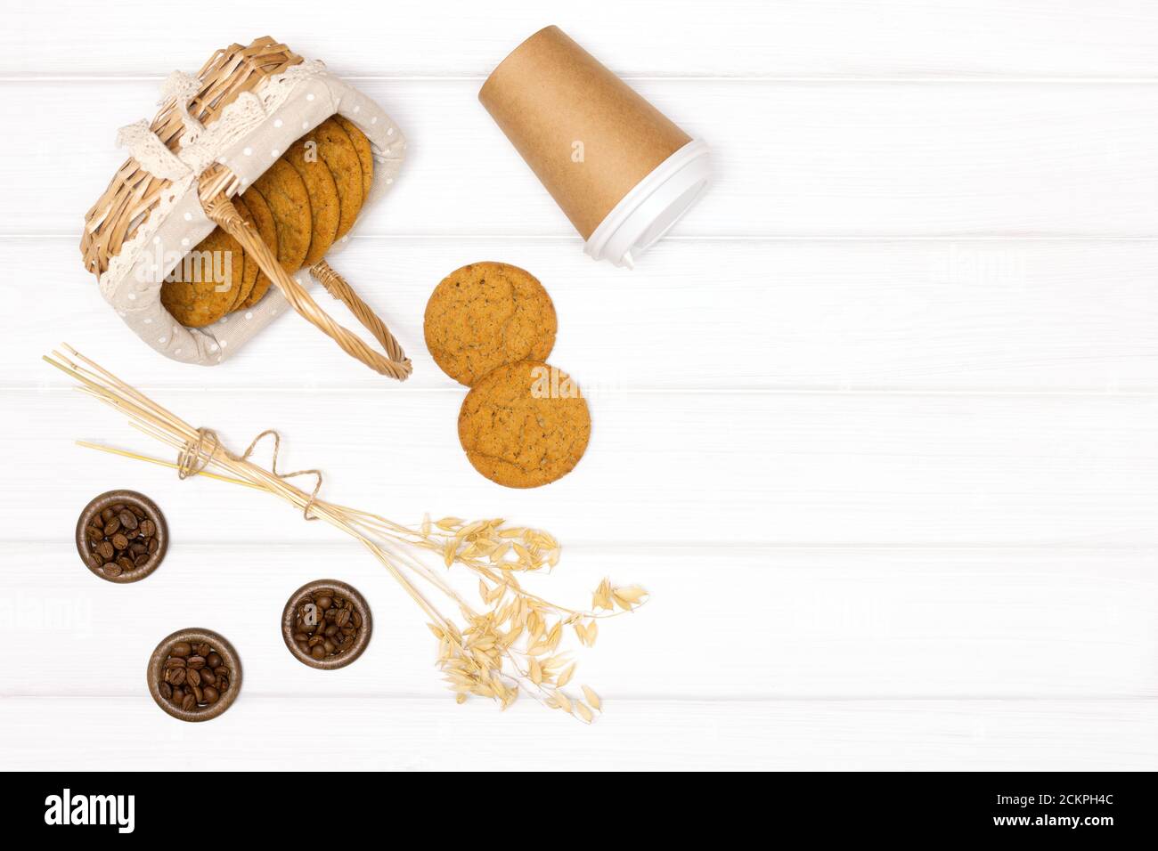 Biscotti di farinata d'avena con tazza di caffè di carta su tavole di legno bianche Foto Stock