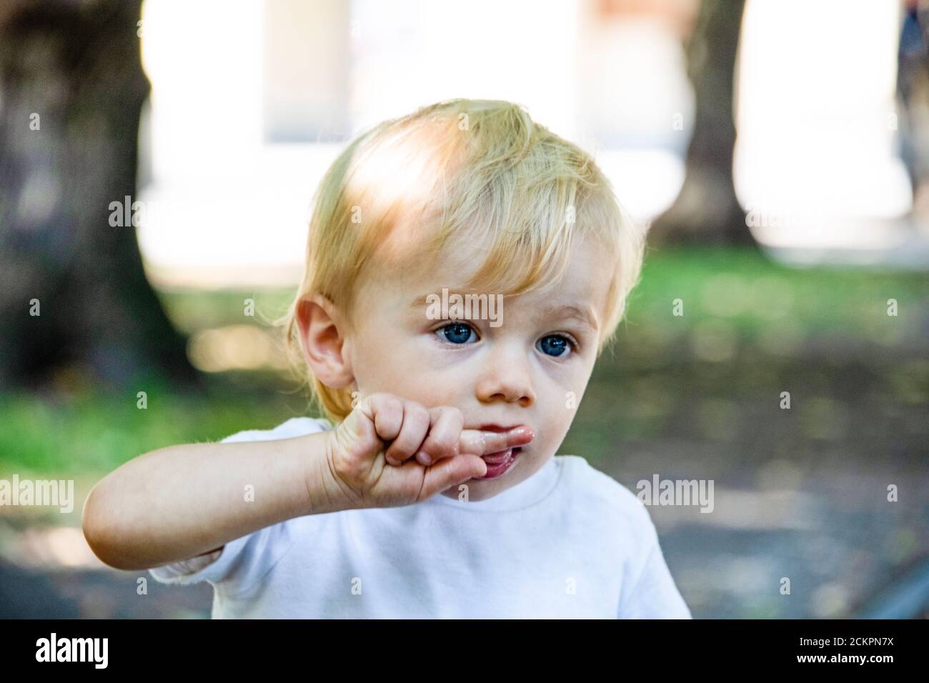 Ritratto di un ragazzo con la mano sulla bocca guardando via Foto Stock