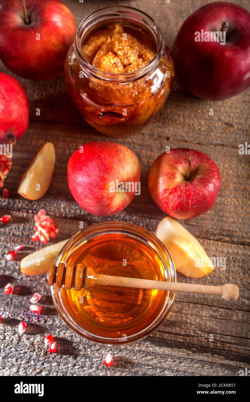 Vacanza ebraica Rosh Hashanah. Mele, melograno e miele sulla tavola rustica in legno. Composizione in stile vintage su sfondo rustico in legno. Foto Stock