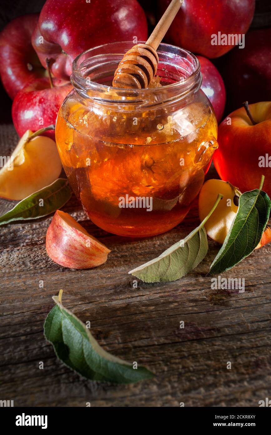 Vacanza ebraica Rosh Hashanah. Mele e miele sulla tavola rustica in legno. Composizione in stile vintage su sfondo rustico in legno. Foto Stock