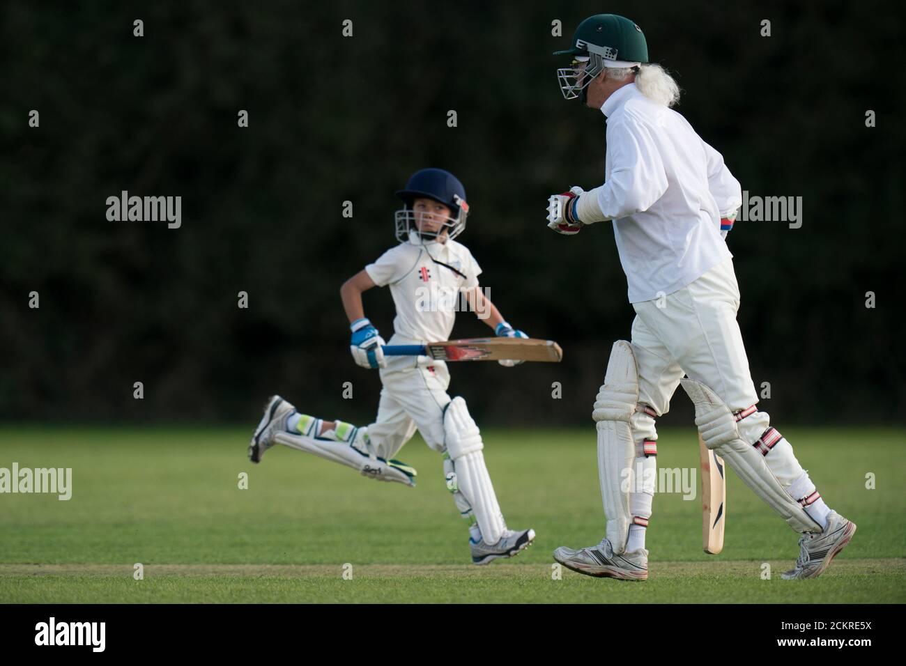 Battitore Making corre durante la partita di cricket del villaggio per tutte le età. Foto Stock