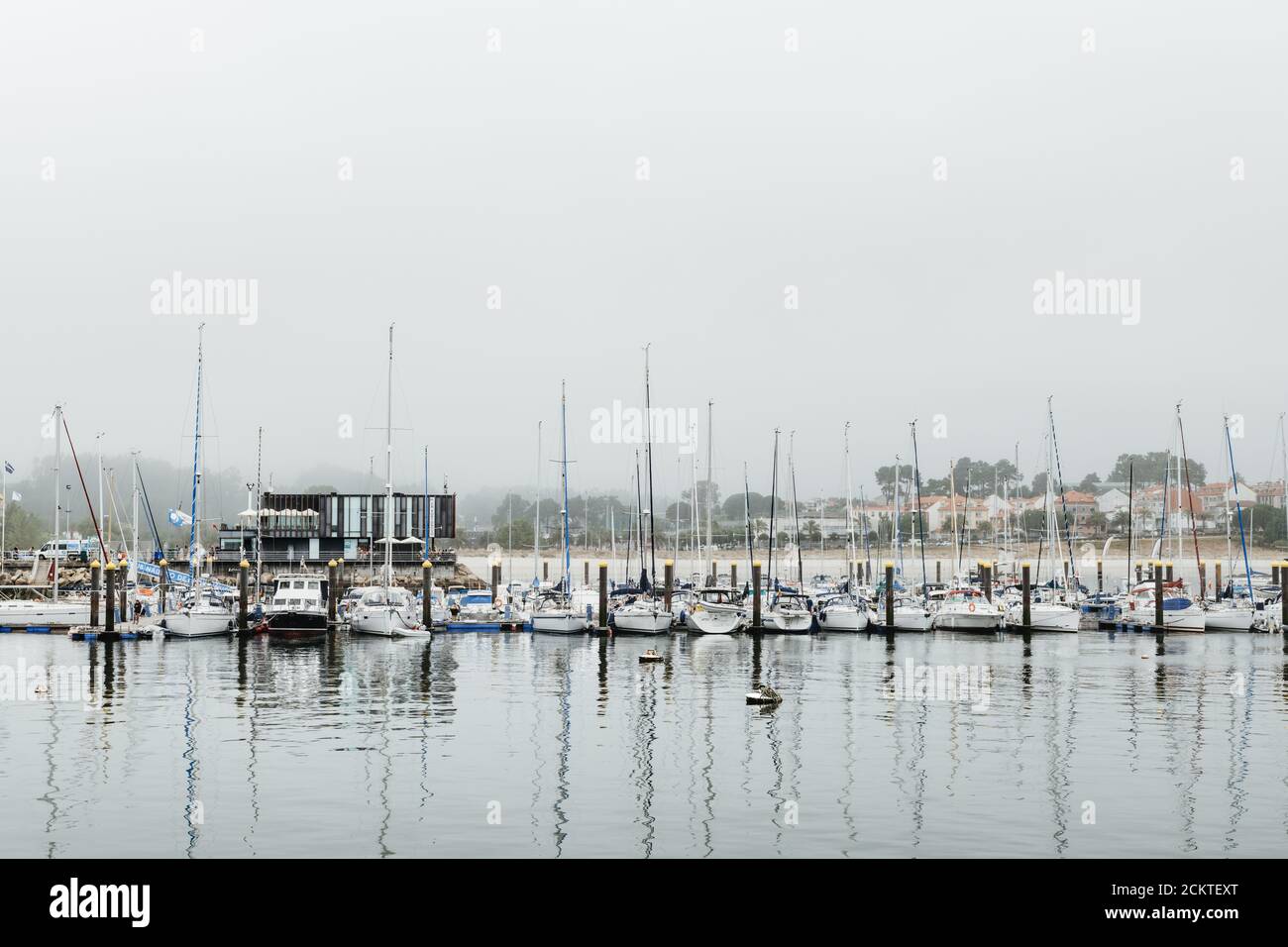 PORTONOVO, SPAGNA - 9 AGOSTO 2020: Vista grandangolare dello yacht club di Portonovo pieno di piccole barche a vela in una giornata estiva piovosa, Pontevedra, Spagna Foto Stock