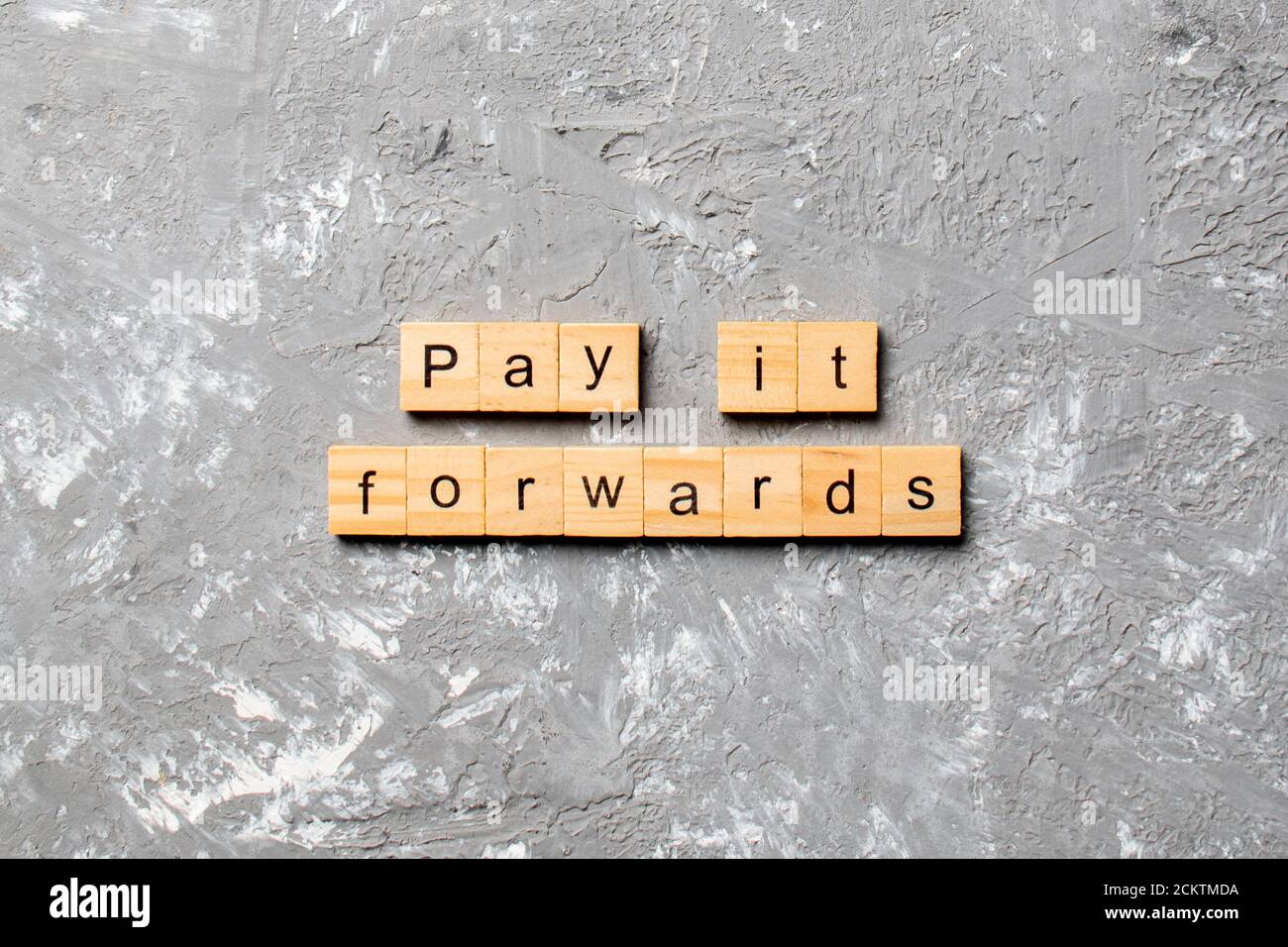 Pay it Forward parola scritta su legno blocco. Pay it Forward testo sulla tabella di cemento per il vostro desing, concetto. Foto Stock