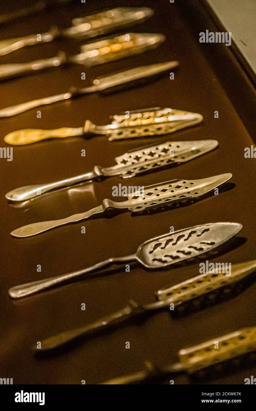 I cucchiai di Assenzio sono posti con un pezzo di zucchero sul bicchiere riempito di assenzio. L'acqua ghiacciata gocciola ad una velocità di una goccia al minuto sopra il cubetto di zucchero e attraverso il cucchiaio nell'alcool caldo della stanza. Ogni goccia ha lasciato la foschia verde lattiginosa nel vetro. Musee de Absynthe a Val-de-Travers, Svizzera Foto Stock