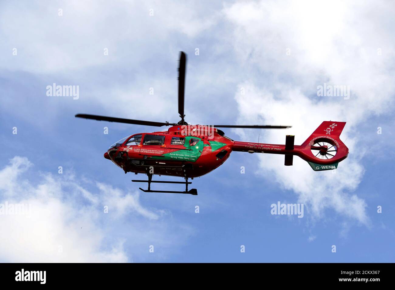 Pontypridd, Galles - Marzo 2018: Un elicottero Airbus del servizio di ambulanza aerea del Galles sullo sfondo di un cielo blu e nuvole bianche. Foto Stock