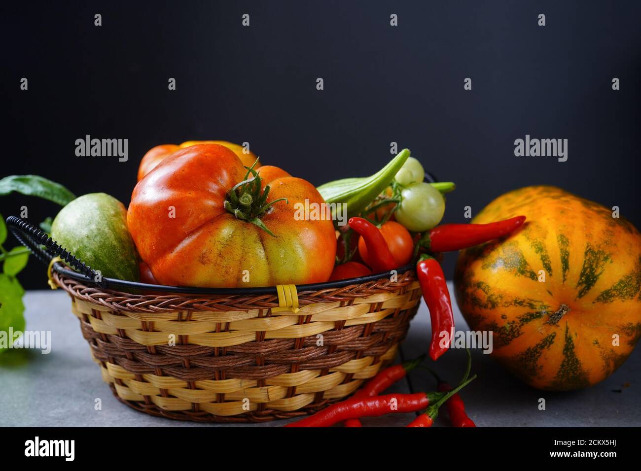 Verdure locali okra, pomodori, peperoncini, cetrioli in un cestino Foto Stock