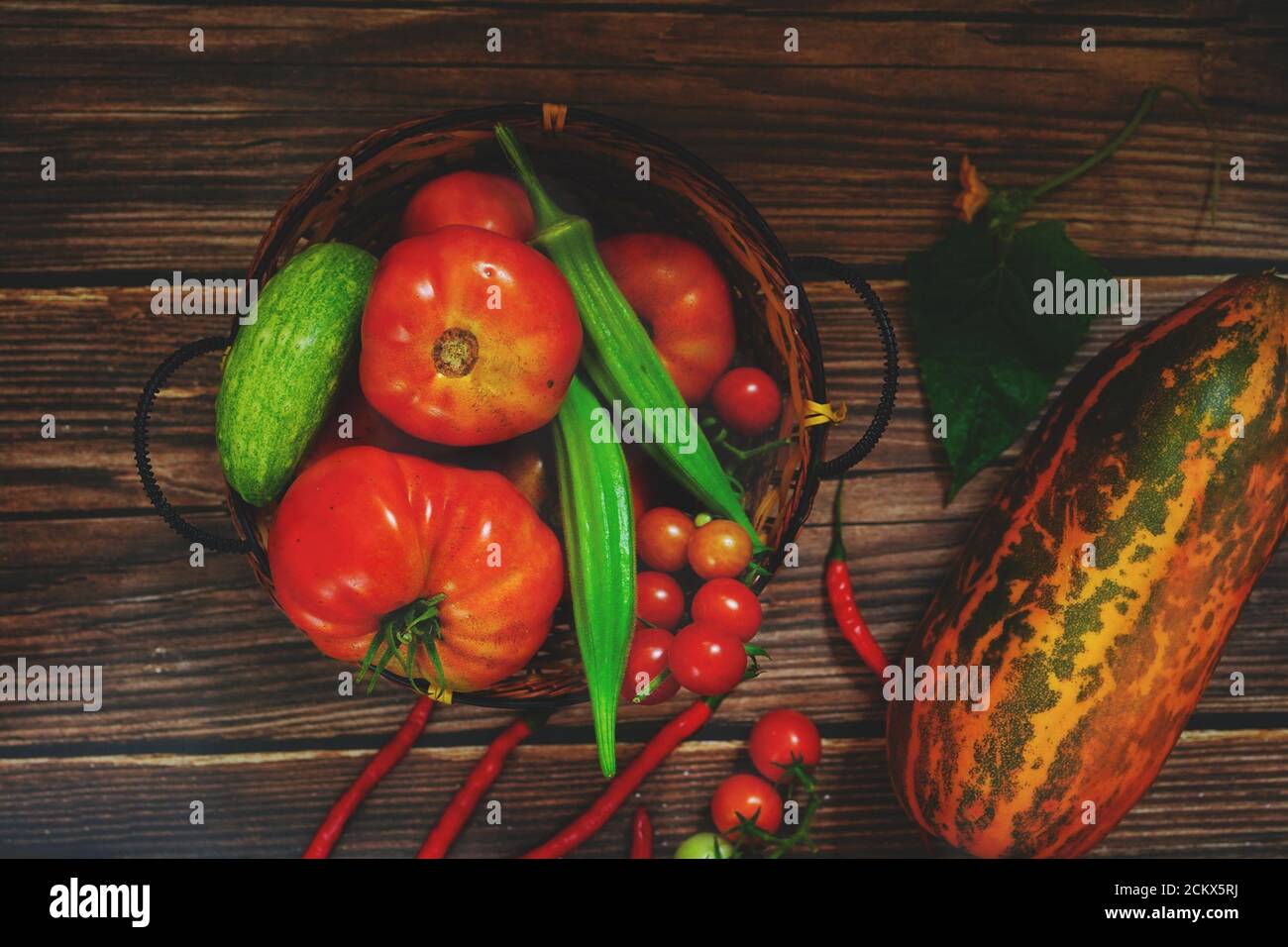 Verdure locali okra, pomodori, peperoncini, cetrioli in un cestino Foto Stock