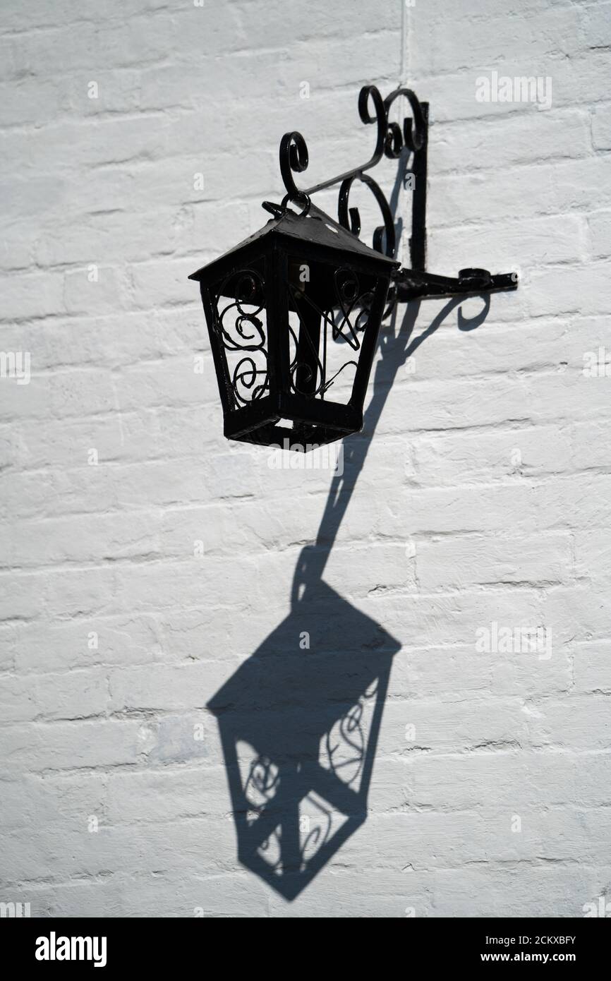 Una lanterna nera ornata su una parete bianca Foto Stock