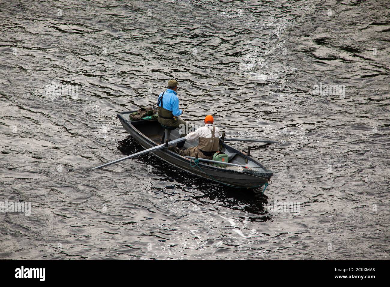 Boatman e Rod fisher pescano il salmone sul fiume Tweed a Kelso, ai confini scozzesi. Foto Stock