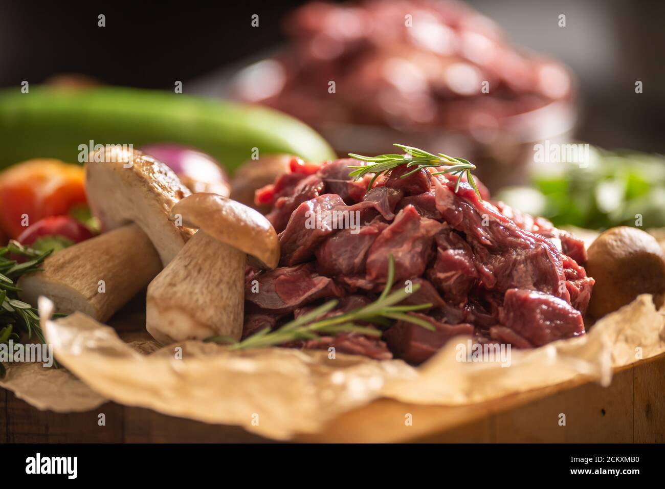 Carne di cervo a fette preparata per stufato di funghi di selvaggina erbe e verdure Foto Stock