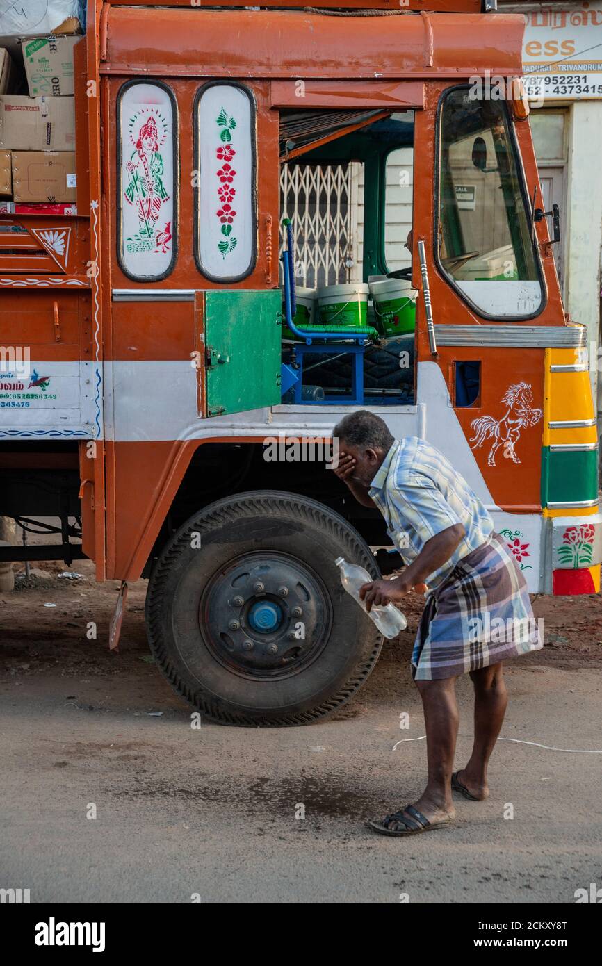 Un conducente di camion che si lava il viso per ottenere fresco dopo guida notturna Foto Stock