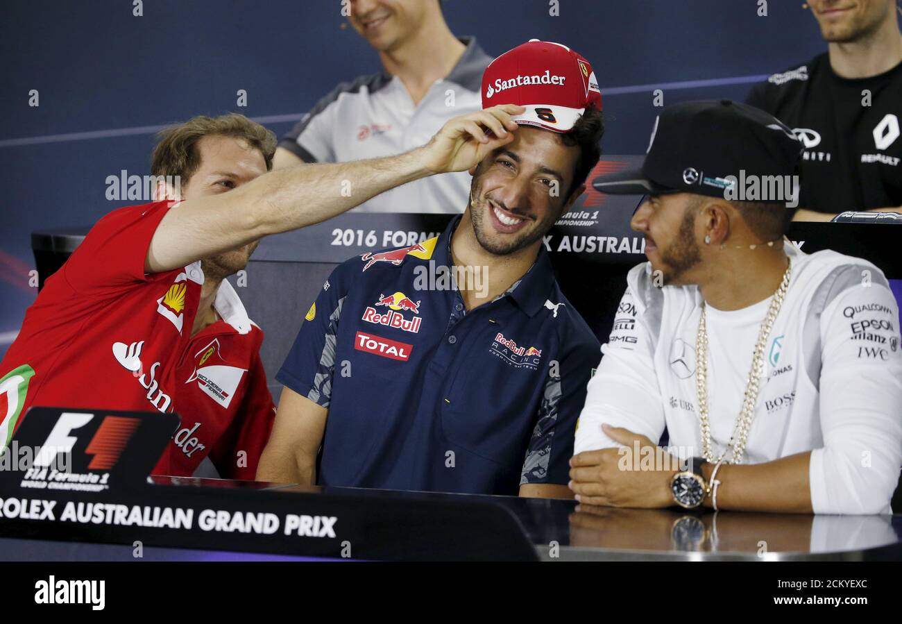 Formula uno - Gran Premio d'Australia - Melbourne, Australia - 17/03/16 -  il pilota Ferrari F1 Sebastian Vettel (L) mette scherzosamente il suo  cappello di scuderia Ferrari in testa al pilota della