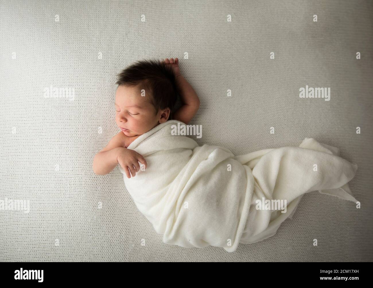 Bambina primogenita con capelli lunghi in dondola bianca Foto Stock