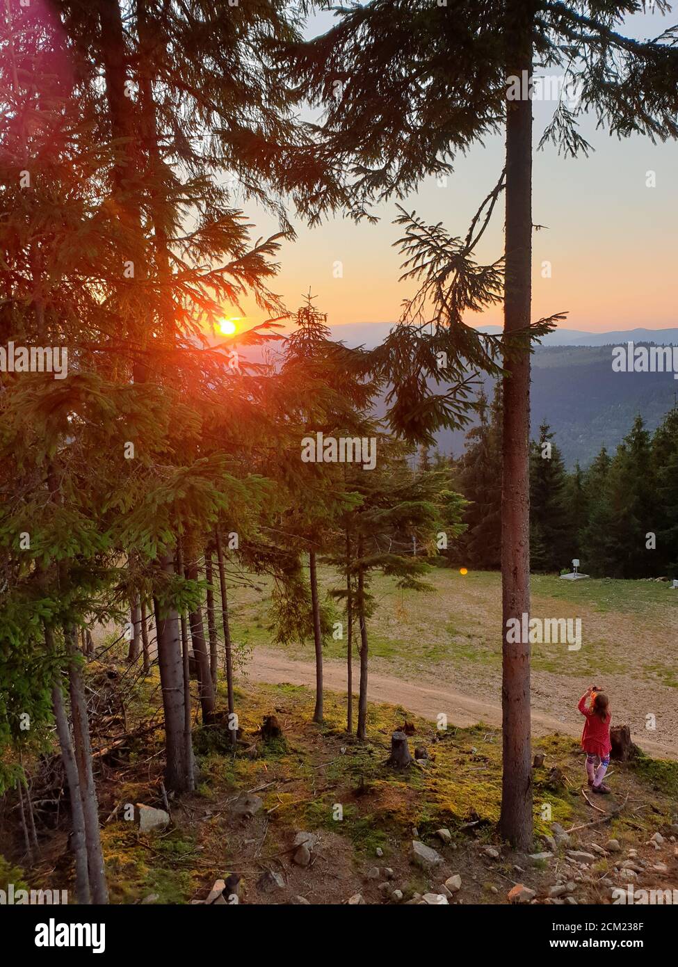Giovane ragazza scattando foto con telefono tramonto in montagna, in Marisel, Cluj contea, Transilvania, Romania. Attività all'aperto in natura mentre sociale Foto Stock