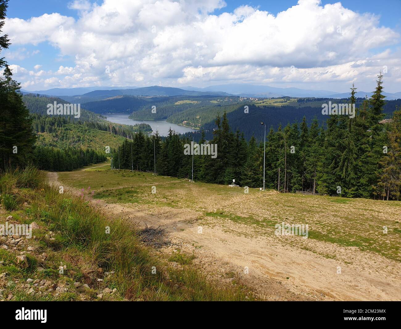 La pista sciistica di Marisel e il lago di Belis in estate nella giornata di sole, Romania. Appuseni scena montagne, Cluj contea, Transilvania, Romania. Pineta, bianco Foto Stock