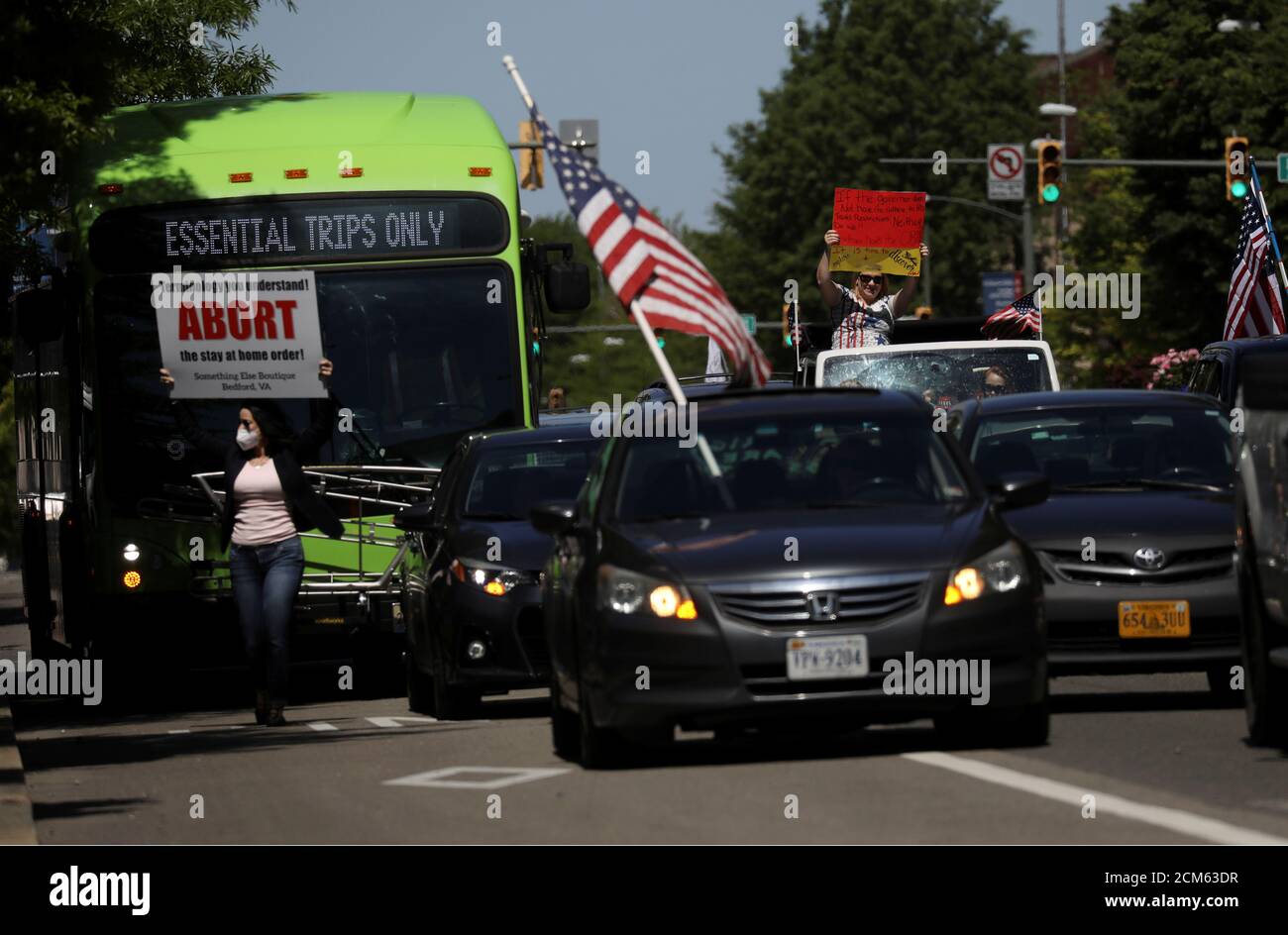 Un autobus commuter è bloccato da dimostranti in veicoli che protestano contro le misure di blocco in seguito alla malattia del coronavirus (COVID-19) focolaio durante una dimostrazione che ha chiesto la riapertura dello stato della Virginia a Richmond, Virginia, Stati Uniti, 22 aprile 2020. REUTERS/Leah Millis Foto Stock