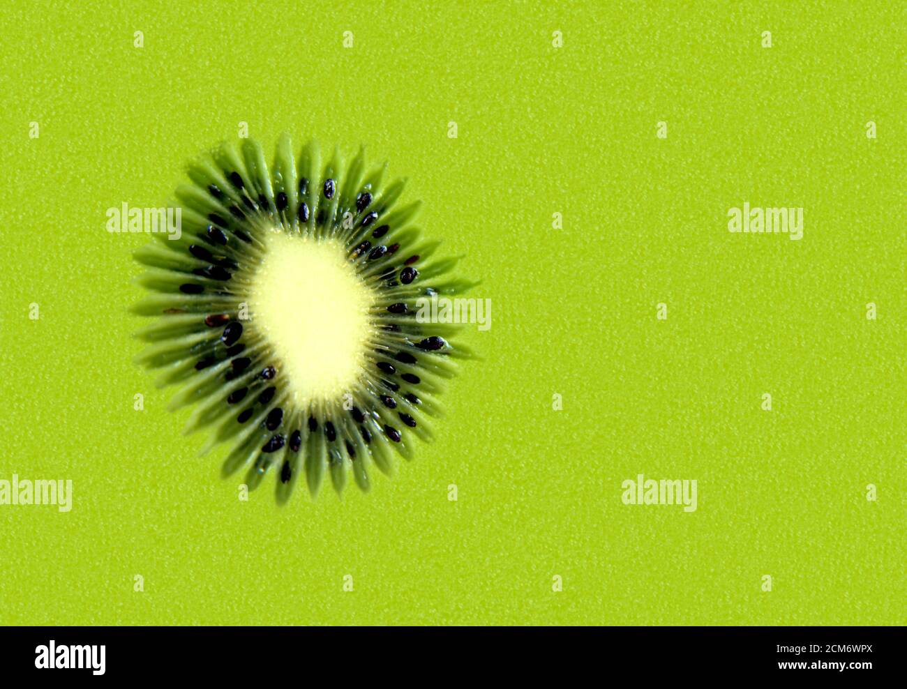Taglio, affettato mezzo kiwifruit polpa astratta sfondo. Per la disposizione piatta, la sovrapposizione, il mockup, lo sfondo, ecc. spazio di copia per il testo o la visualizzazione del prodotto. Foto Stock