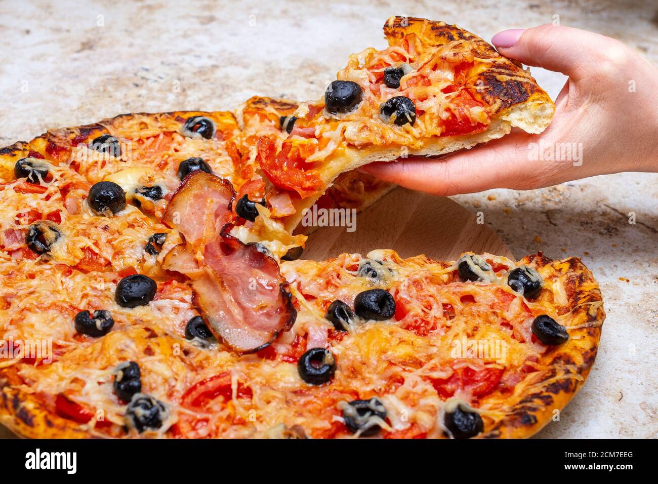 Fare una pizza a casa con pomodoro, olive, prosciutto e formaggio, Cook at home concept. Foto Stock