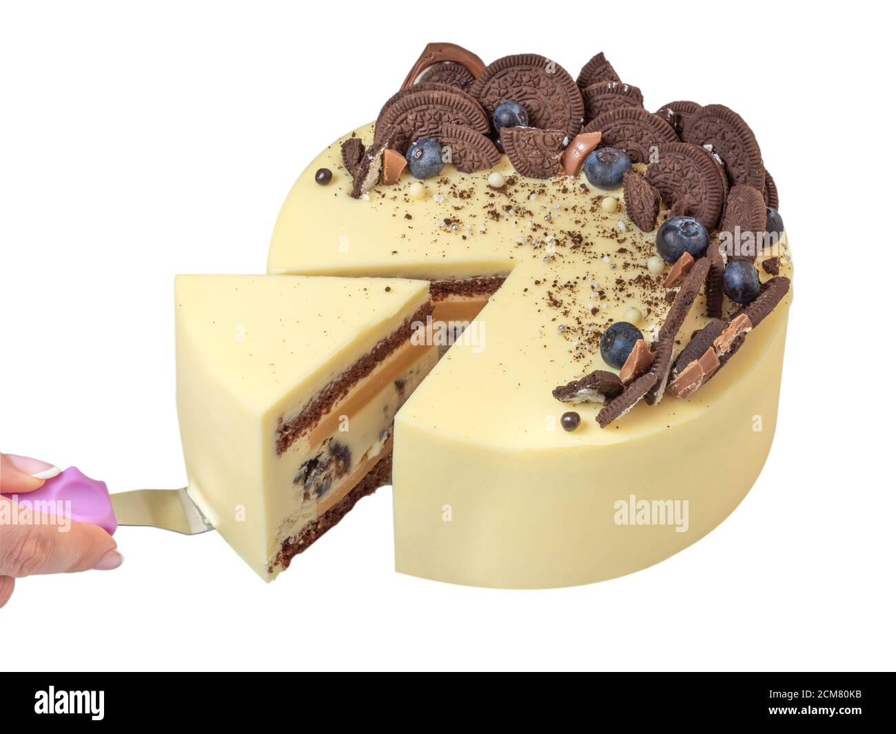 Le mani della donna tagliano la torta. La mano della donna ha tagliato la torta. Fetta di bella torta per una panetteria di famiglia, con biscotti al cioccolato e frutti di bosco decorazione su s. Foto Stock