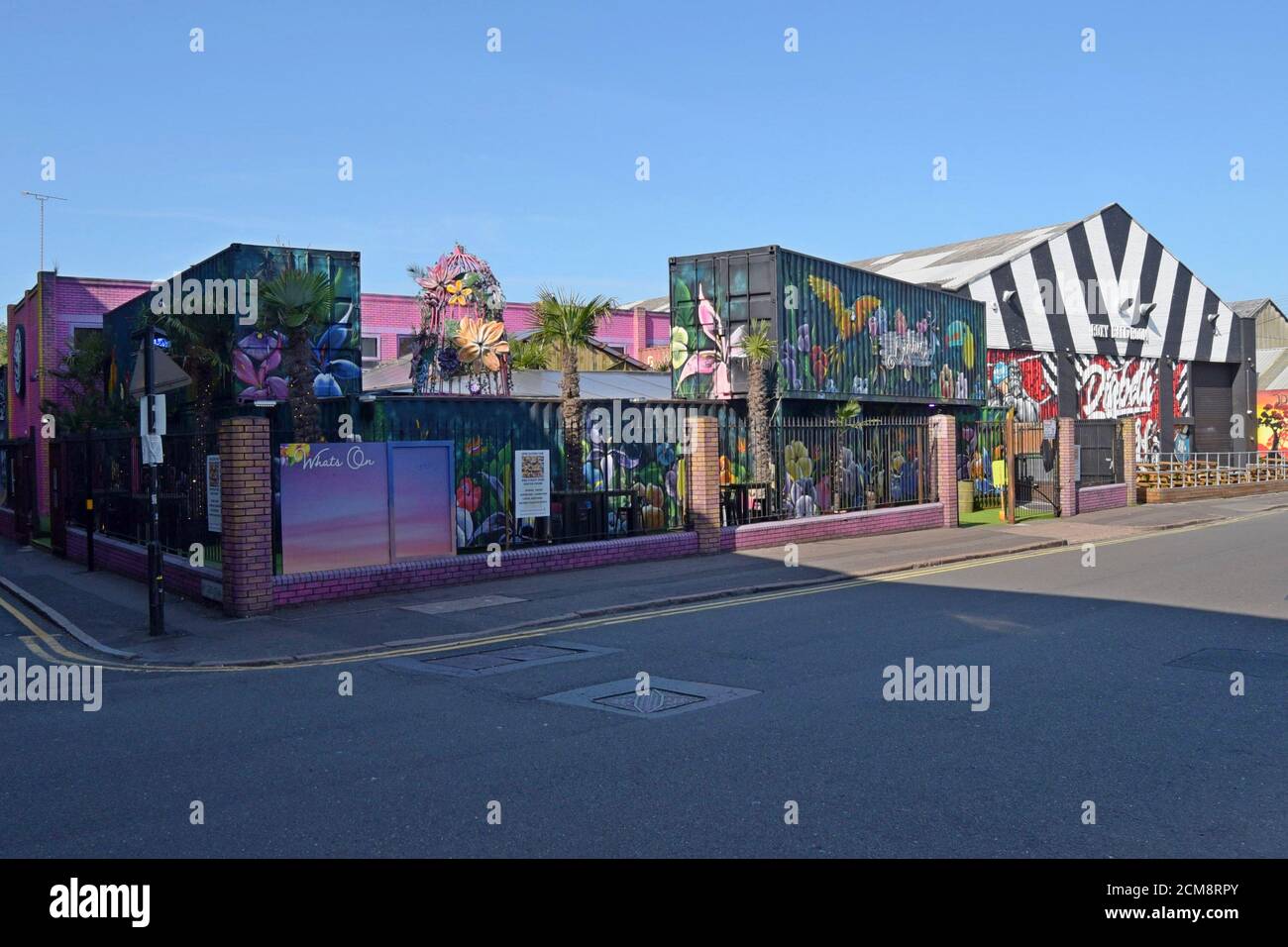 Contenitori per spedizioni riciclati decorati con vivaci murales Street art che creano un'area bar all'aperto al Birdies Bar and Barbeque a Digbeth, Birmingham Foto Stock