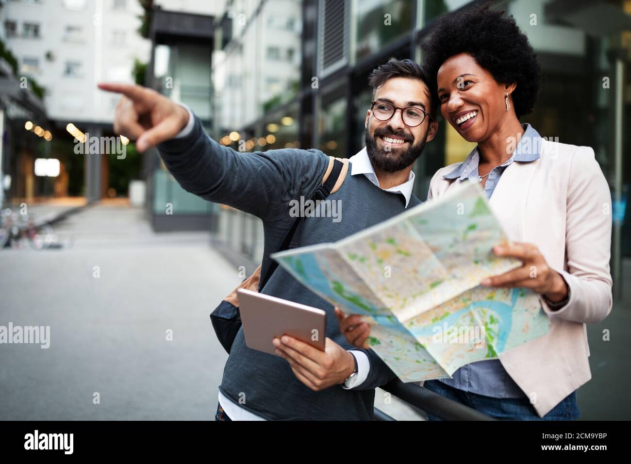 Coppia felice persa in città con una mappa. Viaggi, turismo, concetto di persone Foto Stock