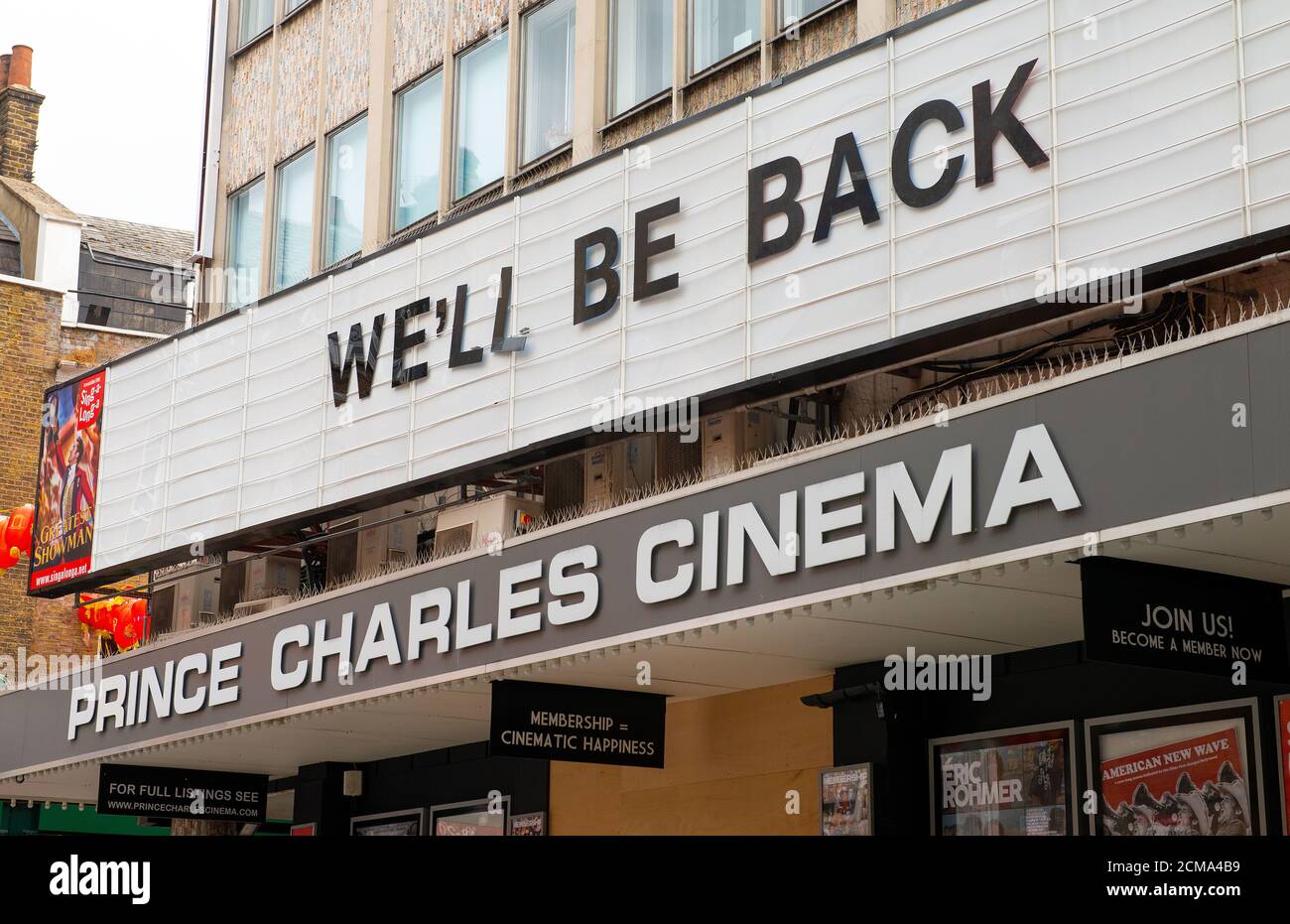 Il cinema Prince Charles con le sue porte chiuse al pubblico durante il blocco pandemico del Coronavirus di Londra con il messaggio "CI TORNEREMO" sopra. Foto Stock