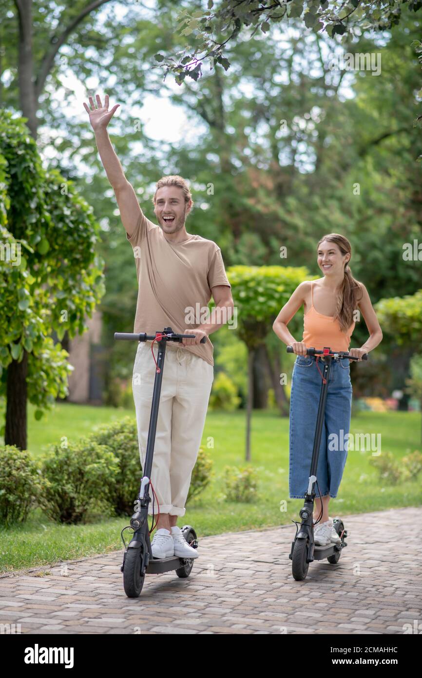 I giovani guidano gli scooter nel parco e guardano eccitato Foto Stock