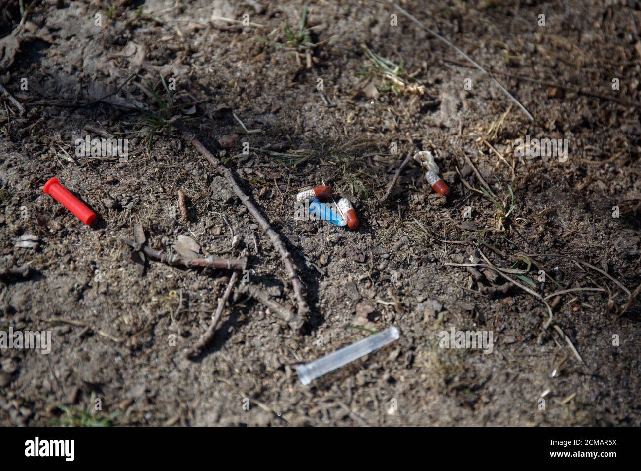 usato ago medico rotto, cappuccio e pillole si trovano a terra Foto Stock