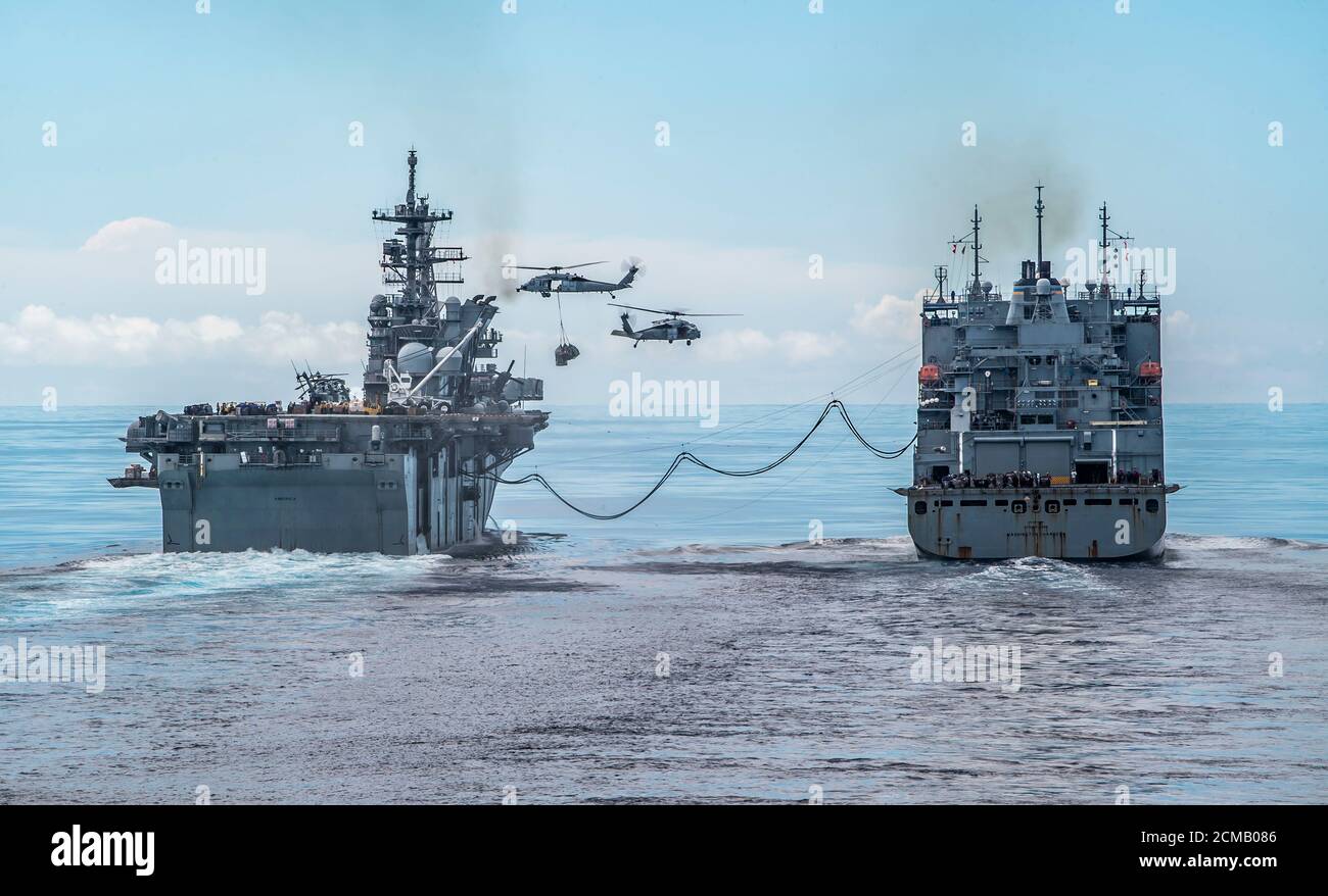 MARE DELLE FILIPPINE (settembre 14, 2020) come si vede dalla nave di atterraggio portuale anfibia USS Germantown (LSD 42), la nave di assalto anfibia USS America (LHA 6), sinistra, conduce un rifornimento in mare con la nave di carico/munizioni a secco USNS Washington Chambers (T-AKE 11). Germantown, parte dell'America Amphibious Ready Group assegnata allo Squadrone anfibio 11, insieme alla 31esima unità di spedizione marina, opera nell'area di responsabilità della 7esima flotta statunitense per migliorare l'interoperabilità con alleati e partner, E servire come una forza di risposta pronta a difendere la pace e la stabilità nella re Indo-Pacifico Foto Stock