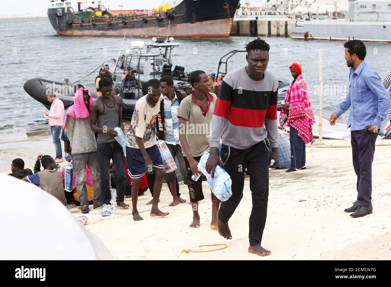 I potenziali migranti camminano dopo lo sbarco da una nave della Marina libica in una base navale nella città costiera di Tripoli, il 7 settembre 2015. I migranti, che avevano cercato di raggiungere l'Europa da Gharabouli, sono stati salvati dalle guardie costiere quando la loro barca si è rotta, secondo le guardie costiere, un'unità delle forze navali libiche. La Libia si è trasformata in un'importante via di transito per i migranti in fuga dalla guerra e dalla povertà. REUTERS/Ismail Zitouny. Foto Stock
