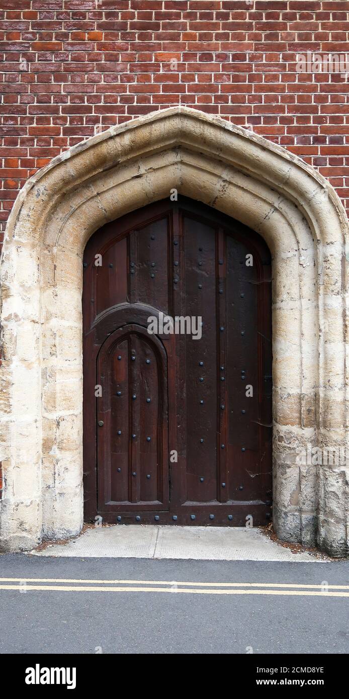 Dettaglio di una vecchia porta pesante in legno all'Università di Cambridge Foto Stock
