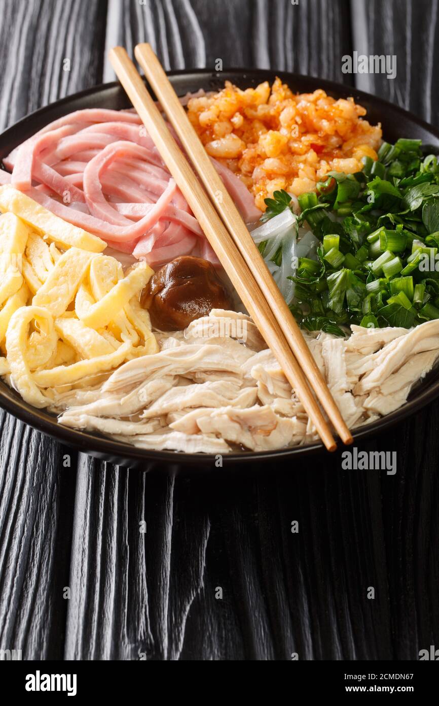 Panna Thang vietnamita di Noodle zuppa con pollo, maiale, uovo, erba e gamberi chiocciole nel piatto sul tavolo. Verticale Foto Stock