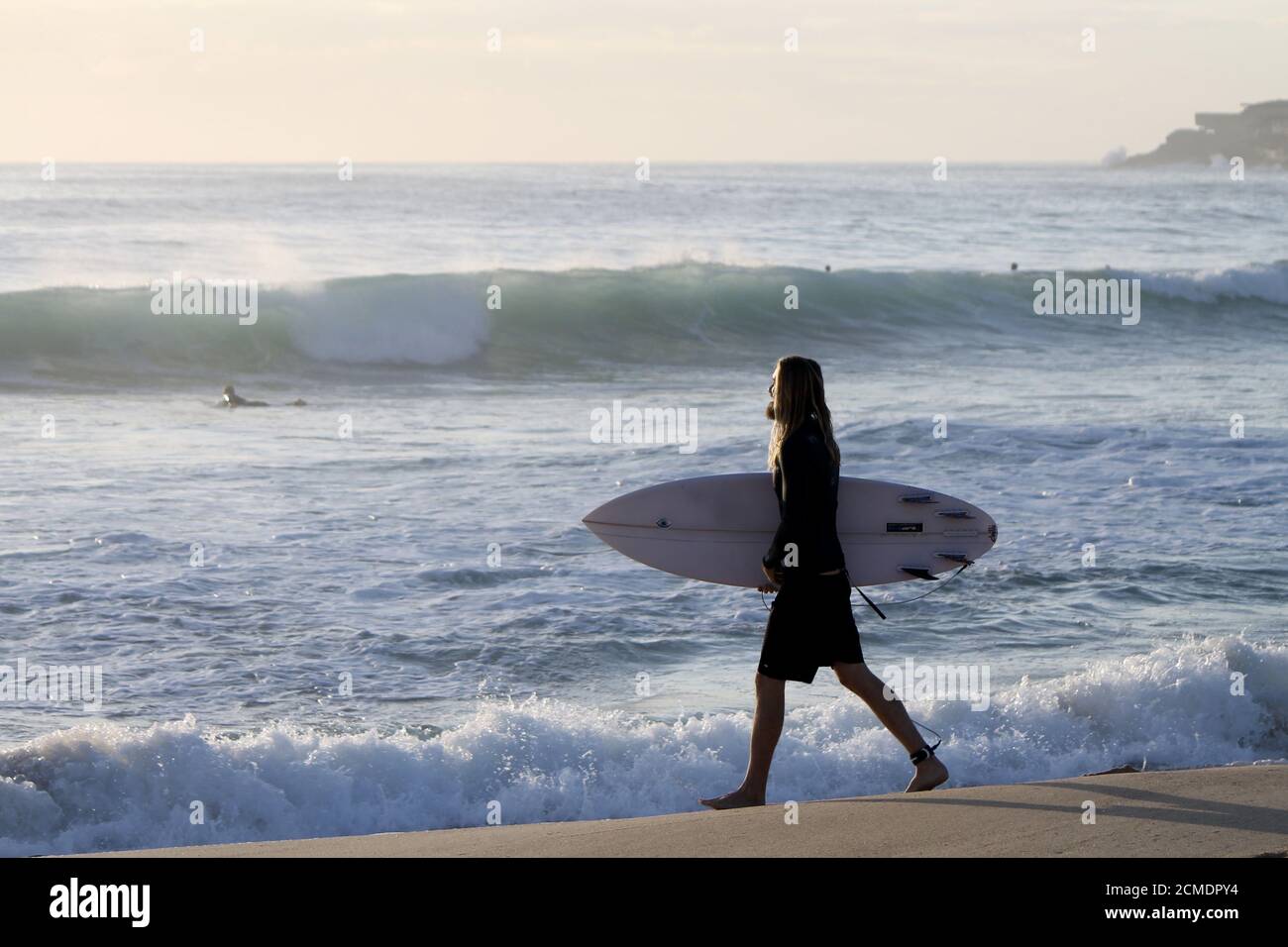 MAROUBRA, AUSTRALIA - Dic 05, 2015: Felice surfista che guarda come gesù che va in acqua al mattino lightMaroubra, nuovo galles del Sud, australia Foto Stock