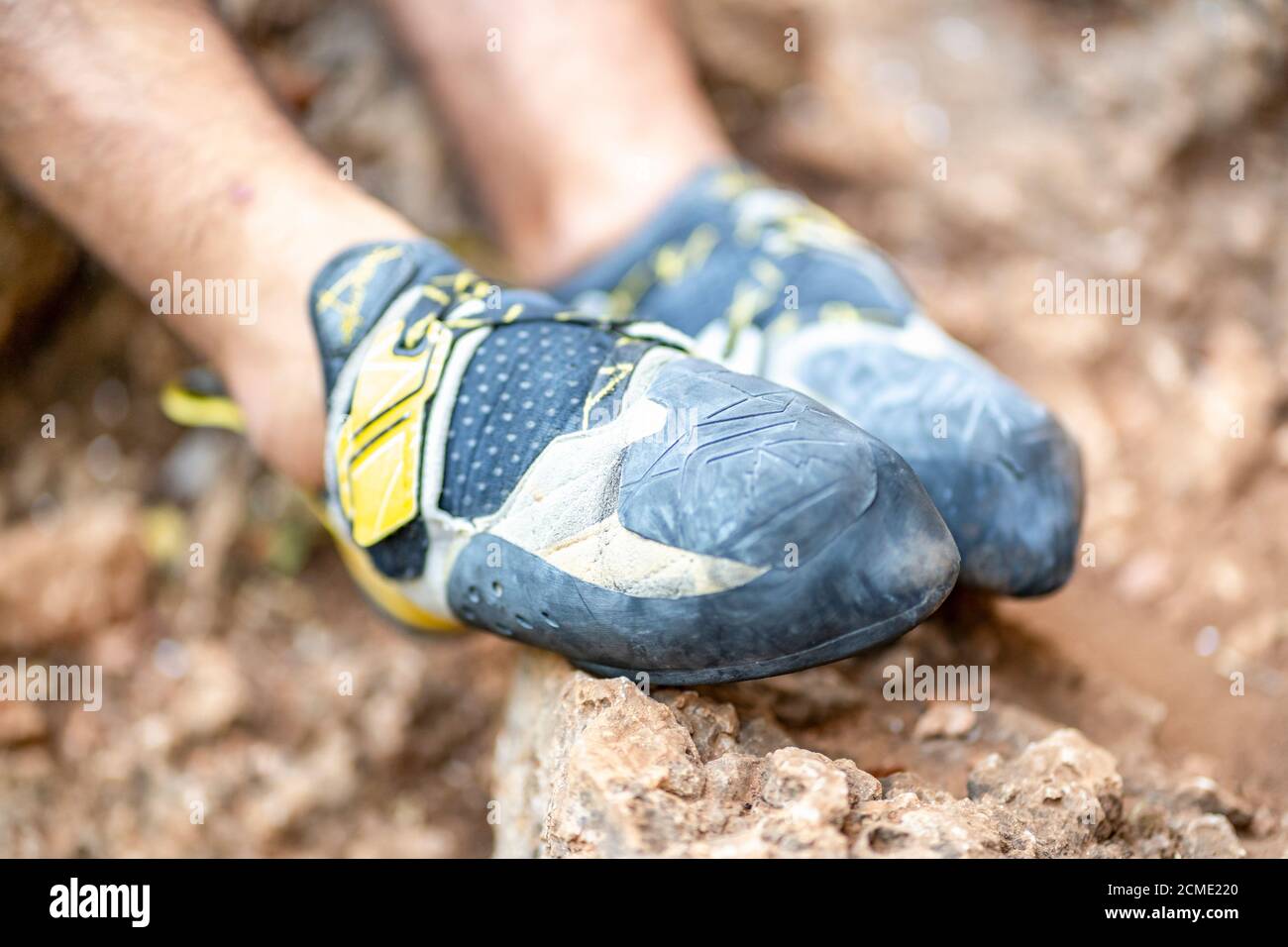 Scarpe da arrampicata sui piedi dell'arrampicatore che riposano sulle rocce Foto Stock