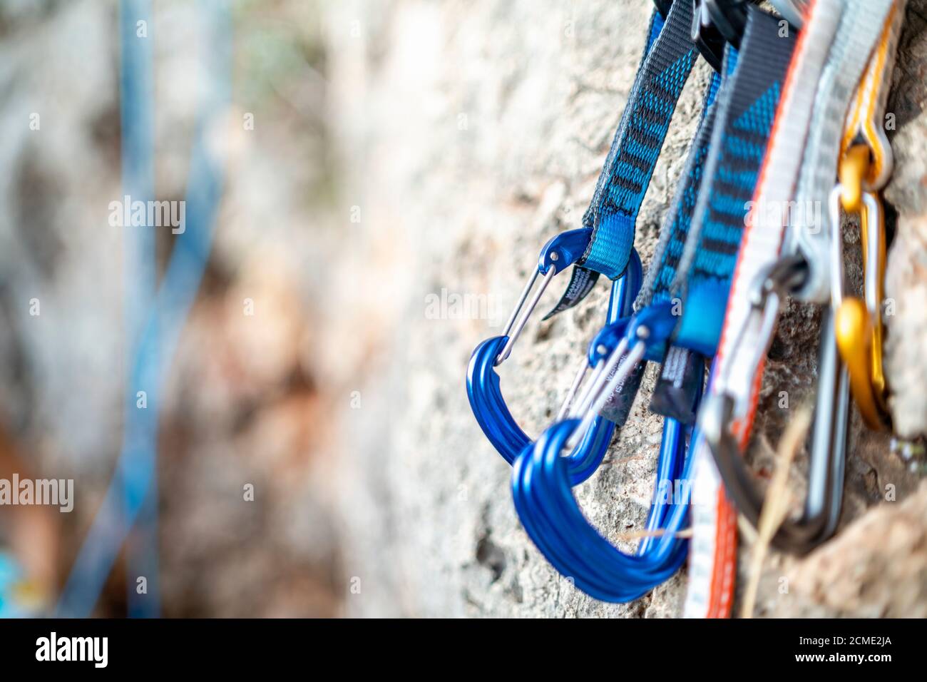 Alcuni moschettoni per scalatori appesi sulla roccia Foto Stock