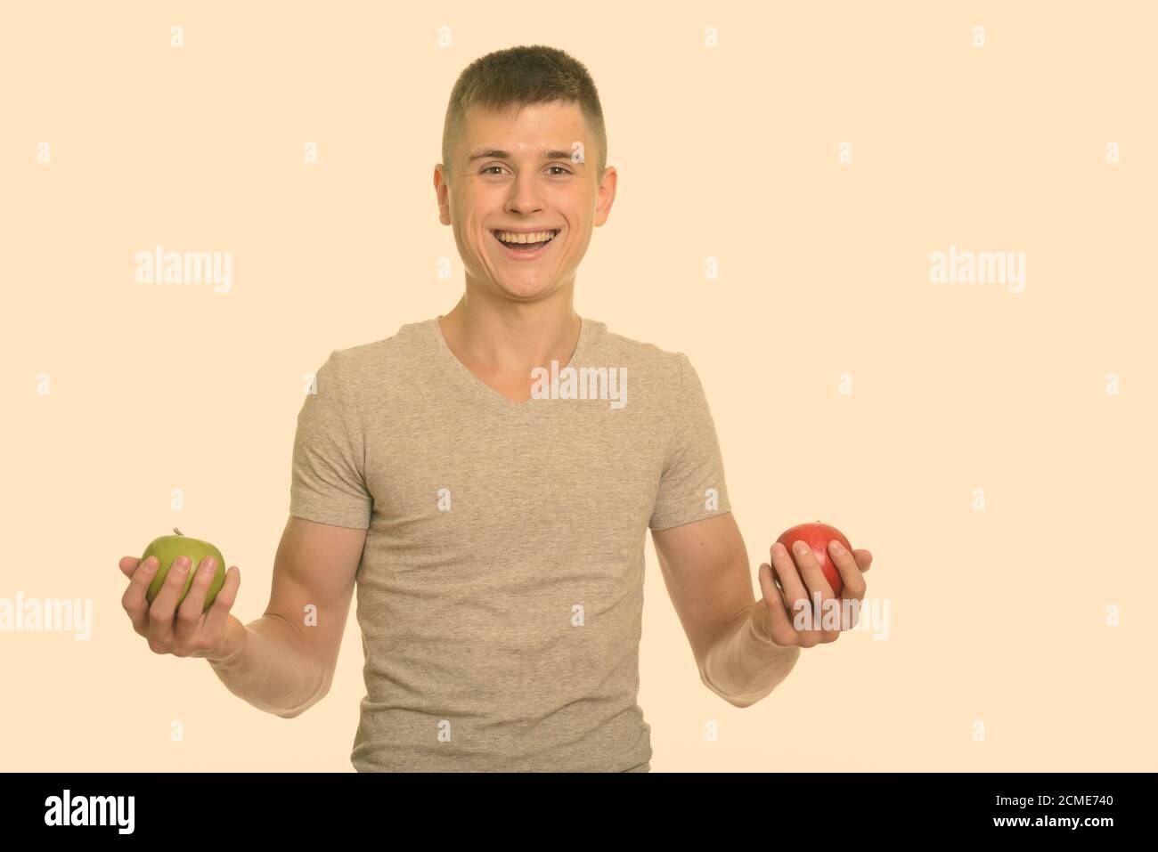 Giovani caucasici felice uomo sorridente tenendo rosso e verde mela Foto Stock