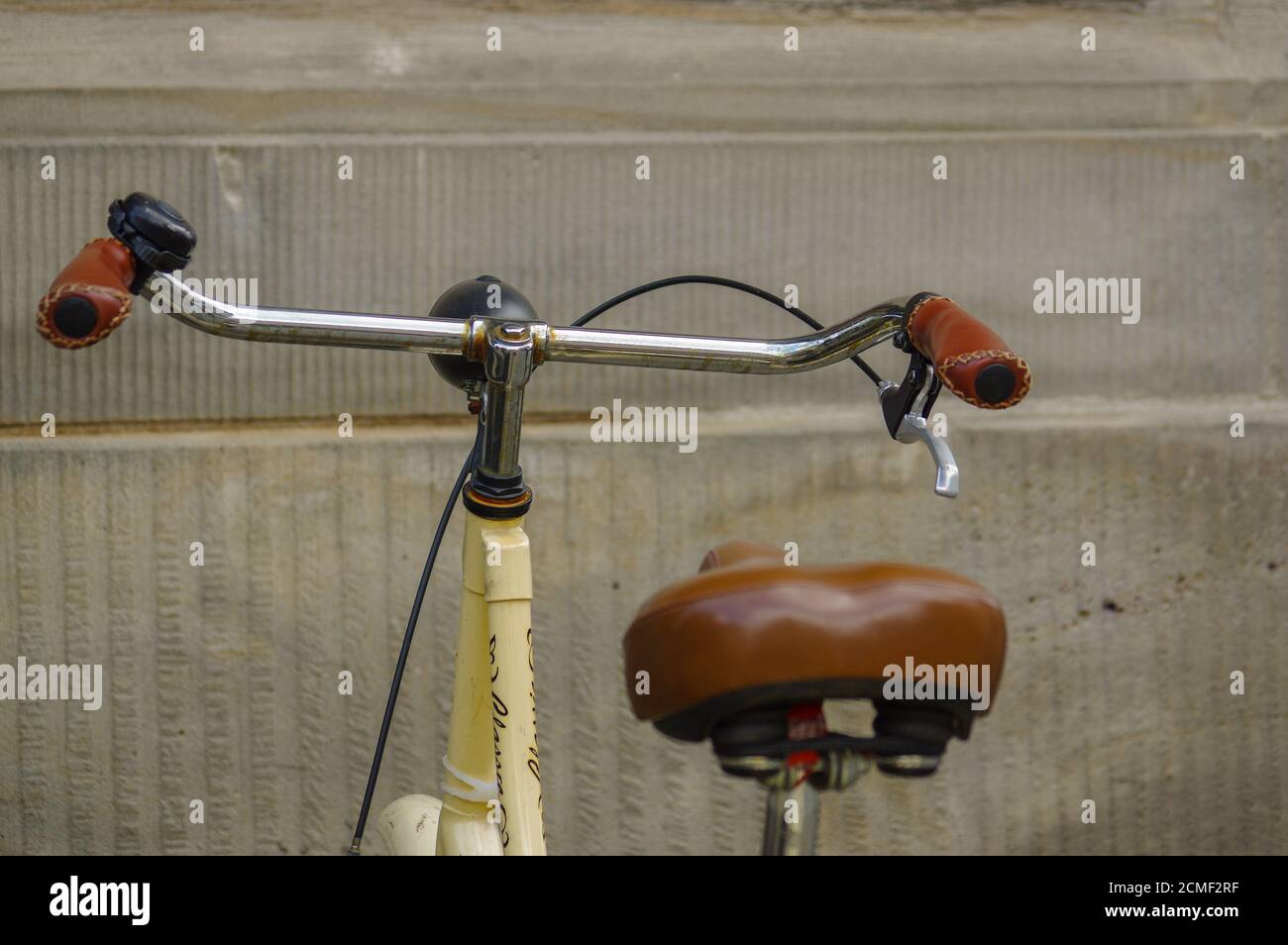 Dettagli del vecchio giallo bicicletta. il sedile in pelle con ammortizzatori e ruota Foto Stock