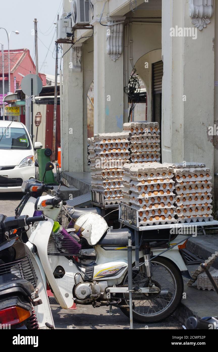 GEORGETOWN, PENANG, MALESIA - 18 aprile 2016: Di uovo di pollo confezionato su uno scooter in attesa di un cliente vicino a un piccolo caffè. Fresco Foto Stock