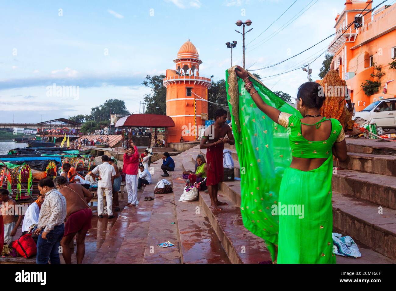 Chitrakoot, Madhya Pradesh, India : dopo il bagno una donna pellegrina mette su un colorato sari verde a Ramghat sul fiume Mandakini, dove durante il thei Foto Stock