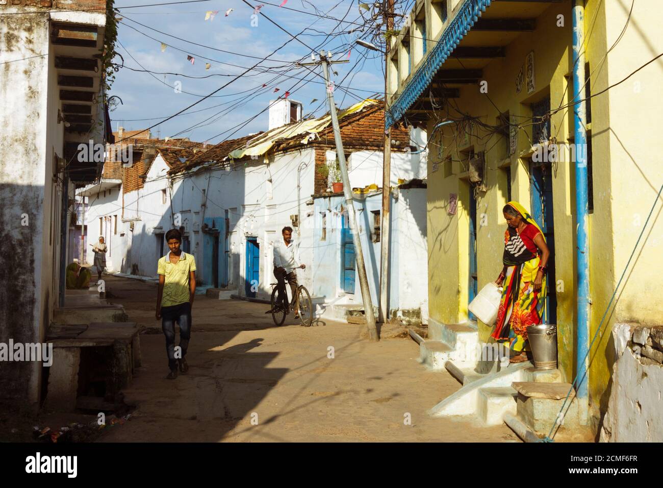 Khajuraho, Madhya Pradesh, India : i villaggi camminano nei vicoli imbiancati del vecchio villaggio di Khajuraho. Foto Stock
